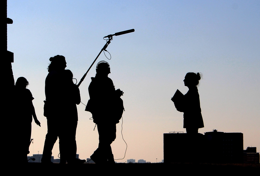 A image of a film crew silhouette speaking with The Rees Hotel Film Unit Liaison Manager to arrange accommodation needs.